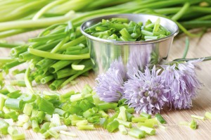 Chopped chives and flowers on bamboo board